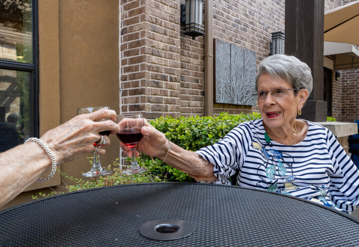 Senior Woman Enjoying Her Glass of Red Wine Outdoors of Independent Living Facility Senior Woman Enjoying Her Glass of Red Wine Outdoors of Independent Living Facility