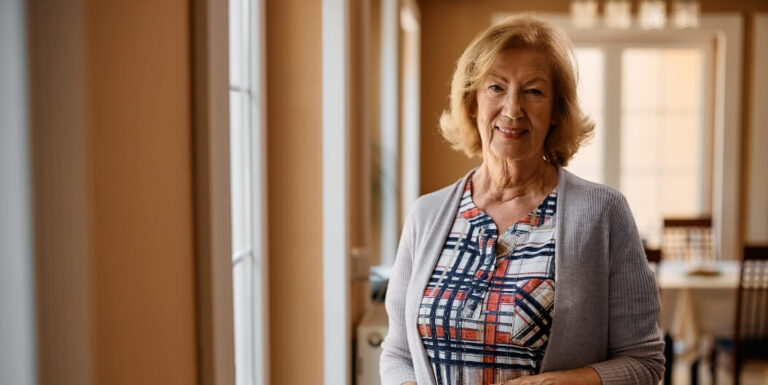 Senior Woman Standing in Bright Hallway at Independent Living Facility